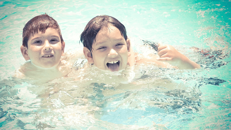 Zwei Kinder spielen in einem Pool