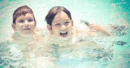 Zwei Kinder spielen in einem Pool