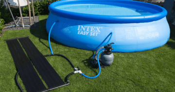 Das Bild zeigt einen Pool mit einer Solar-Heizung, die neben dem Pool liegt. Beide sind mittels Schlauch miteinander verbunden